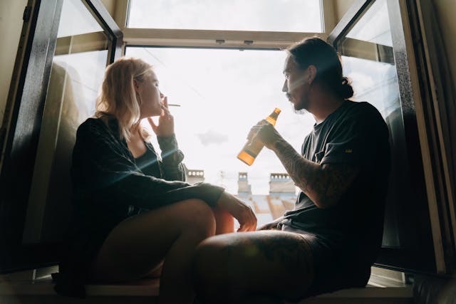 Woman smoking and man drinking