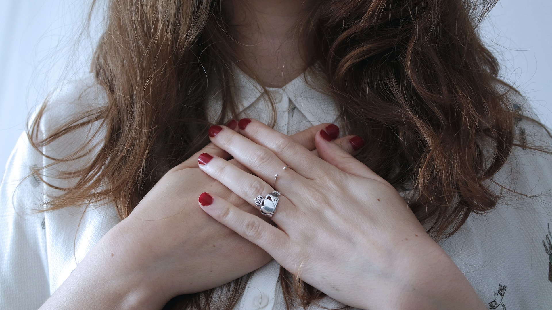 A woman holding her hands over her heart